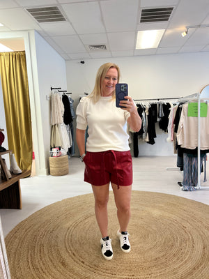 Red leather shorts with white sweater top