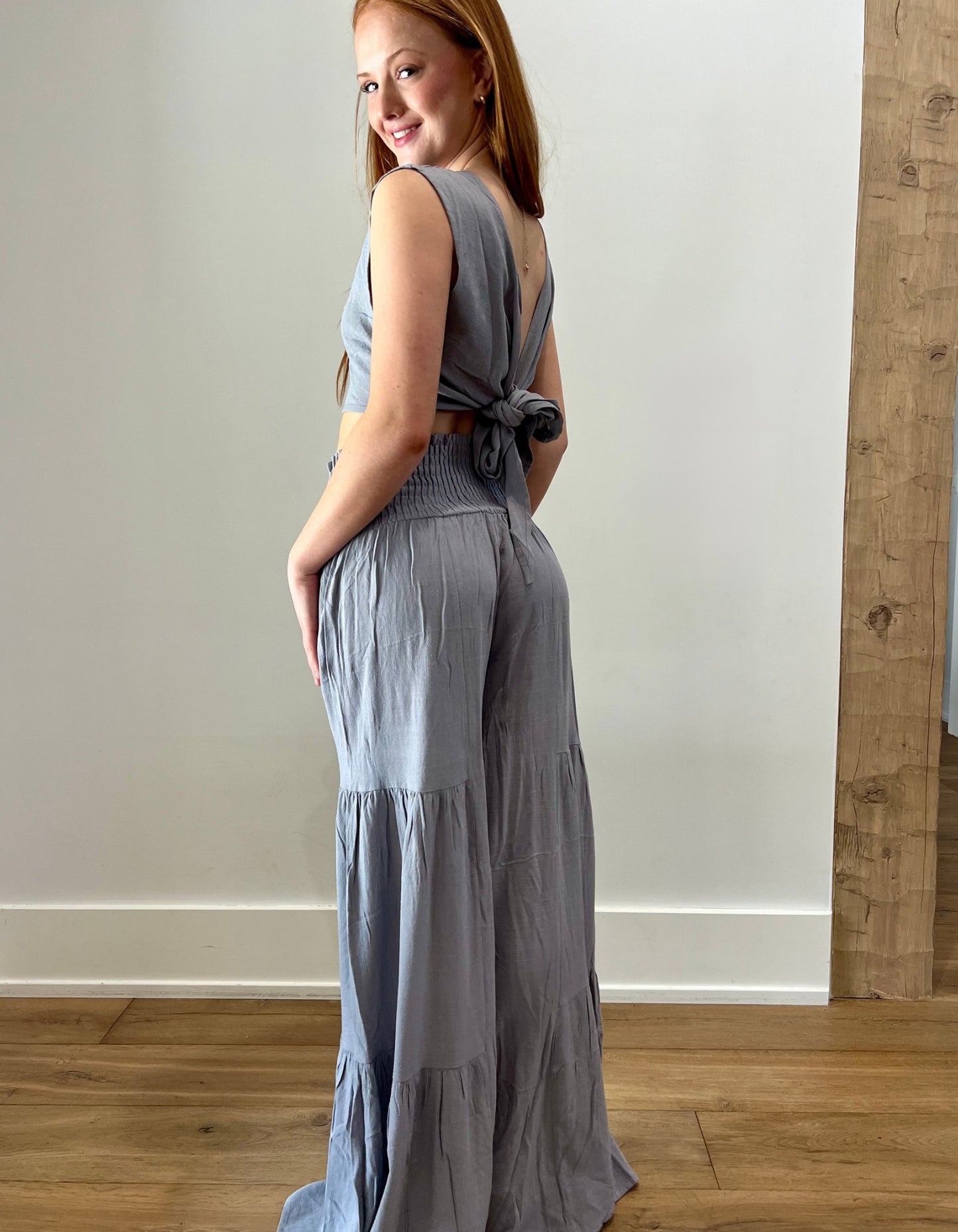 Gray sleeveless top with flowy pants, back view